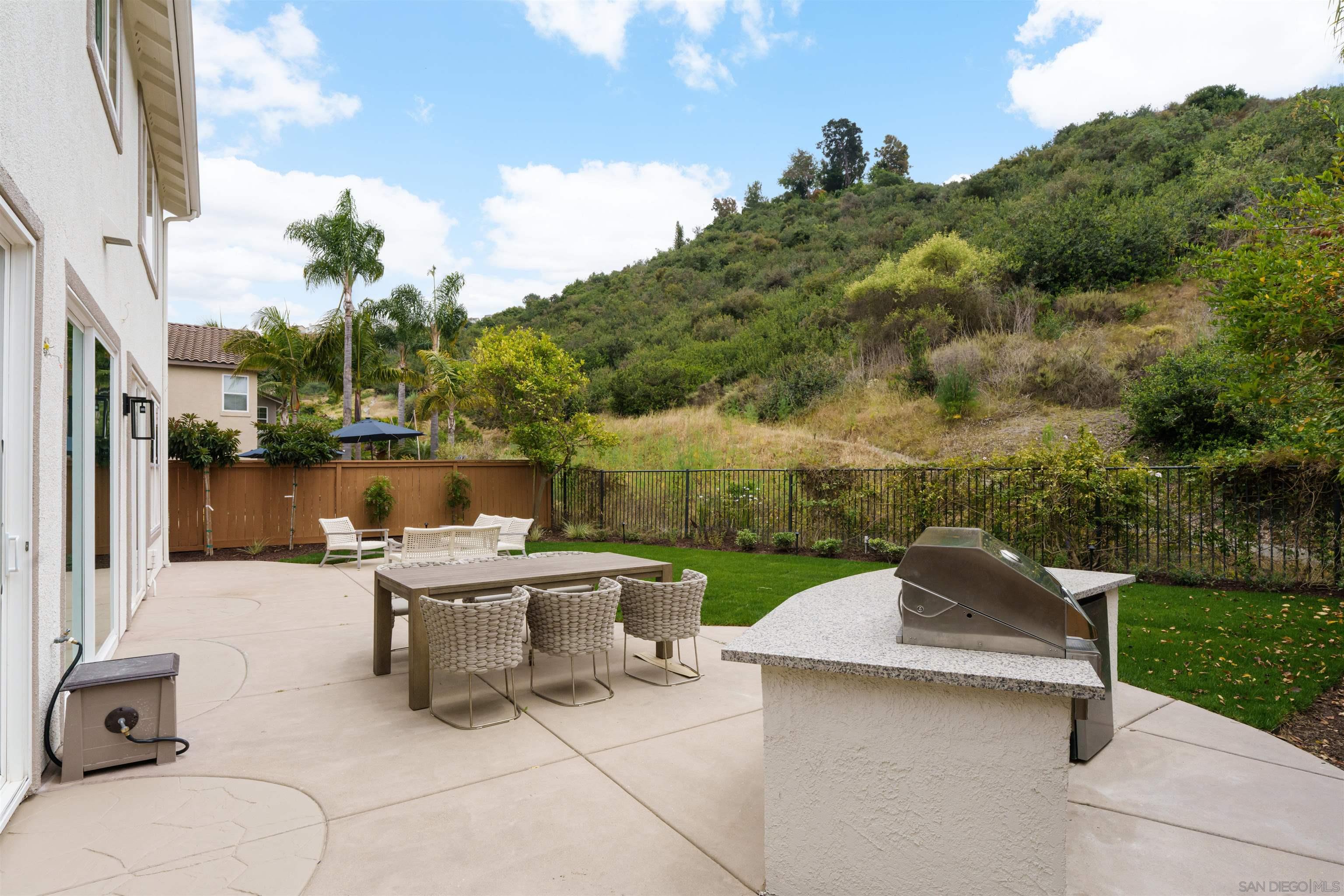 5077 Ashberry Road Carlsbad, CA 92008 - Photo 14 of 35 a view of a patio with a table chairs and a fire pit