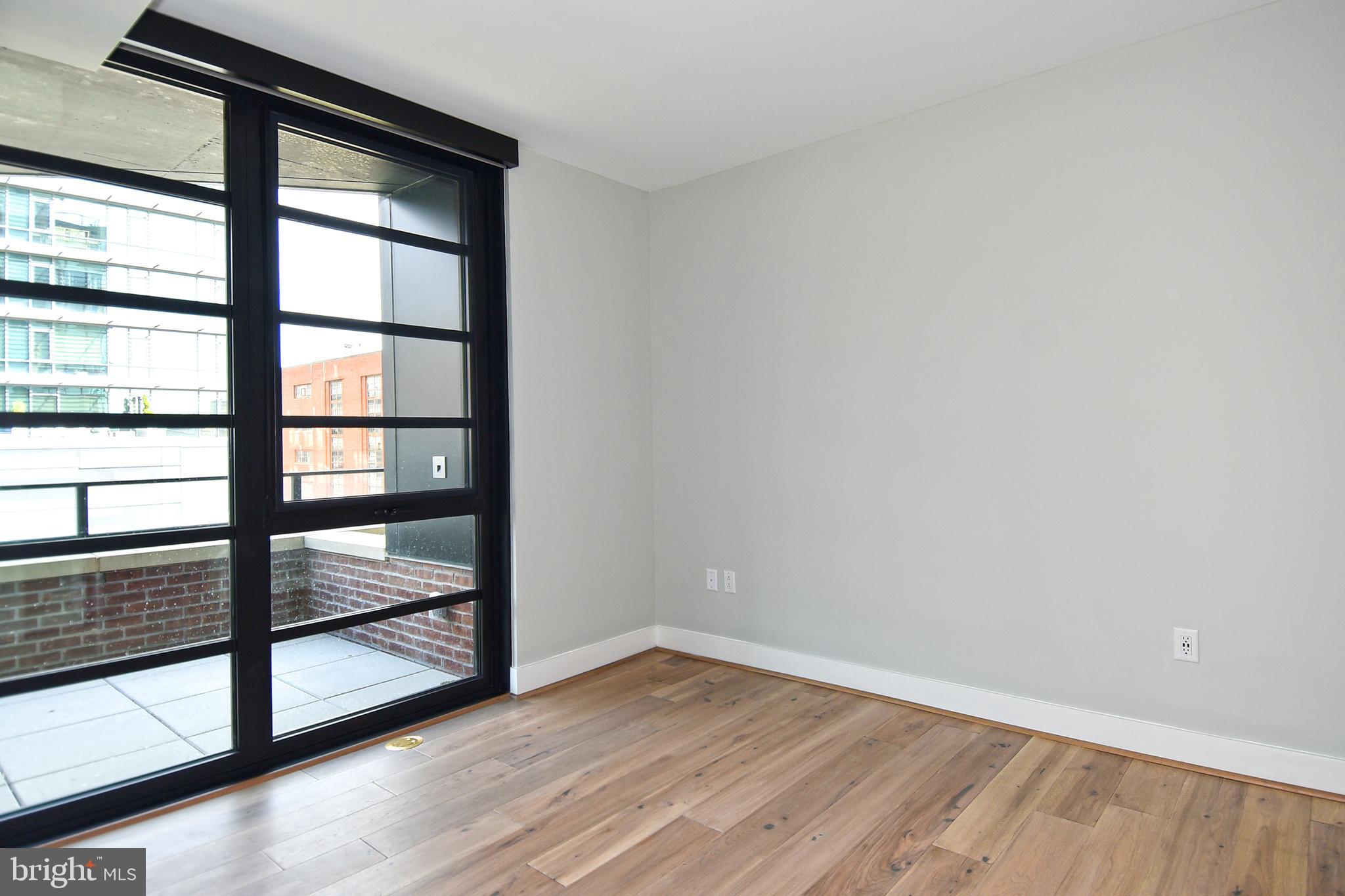 1300 4th Street Southeast, Unit 413 Washington, DC 20003 - Photo 16 of 47 an empty room with wooden floor and windows