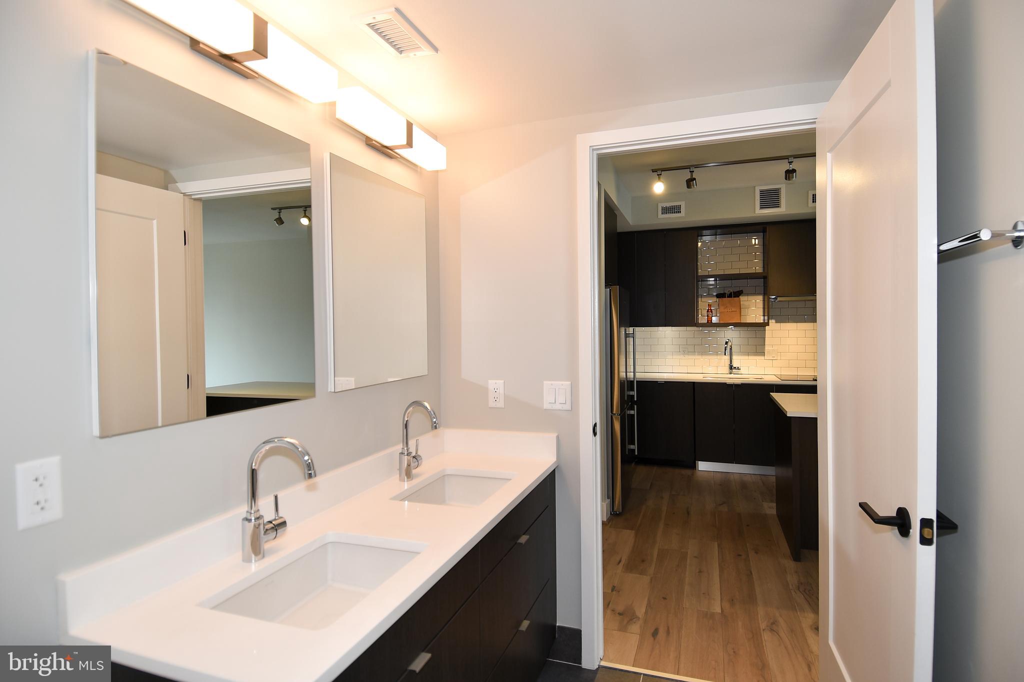 1300 4th Street Southeast, Unit 413 Washington, DC 20003 - Photo 22 of 47 a en suite bathroom with a double vanity sink and a mirror