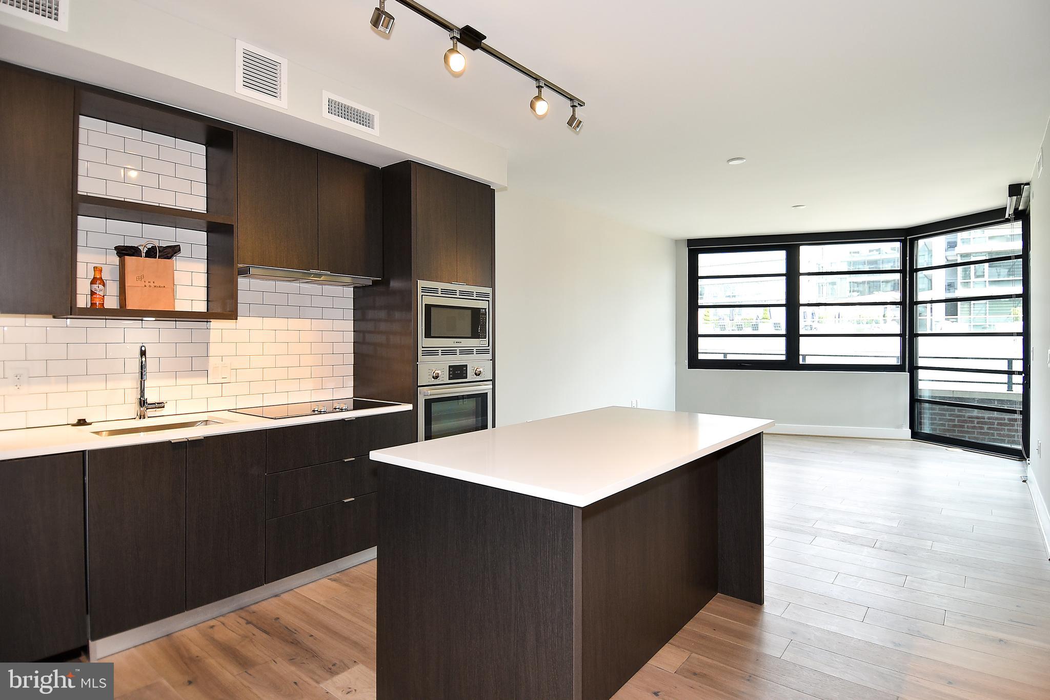 1300 4th Street Southeast, Unit 413 Washington, DC 20003 - Photo 4 of 47 a kitchen with a sink and a wooden floor