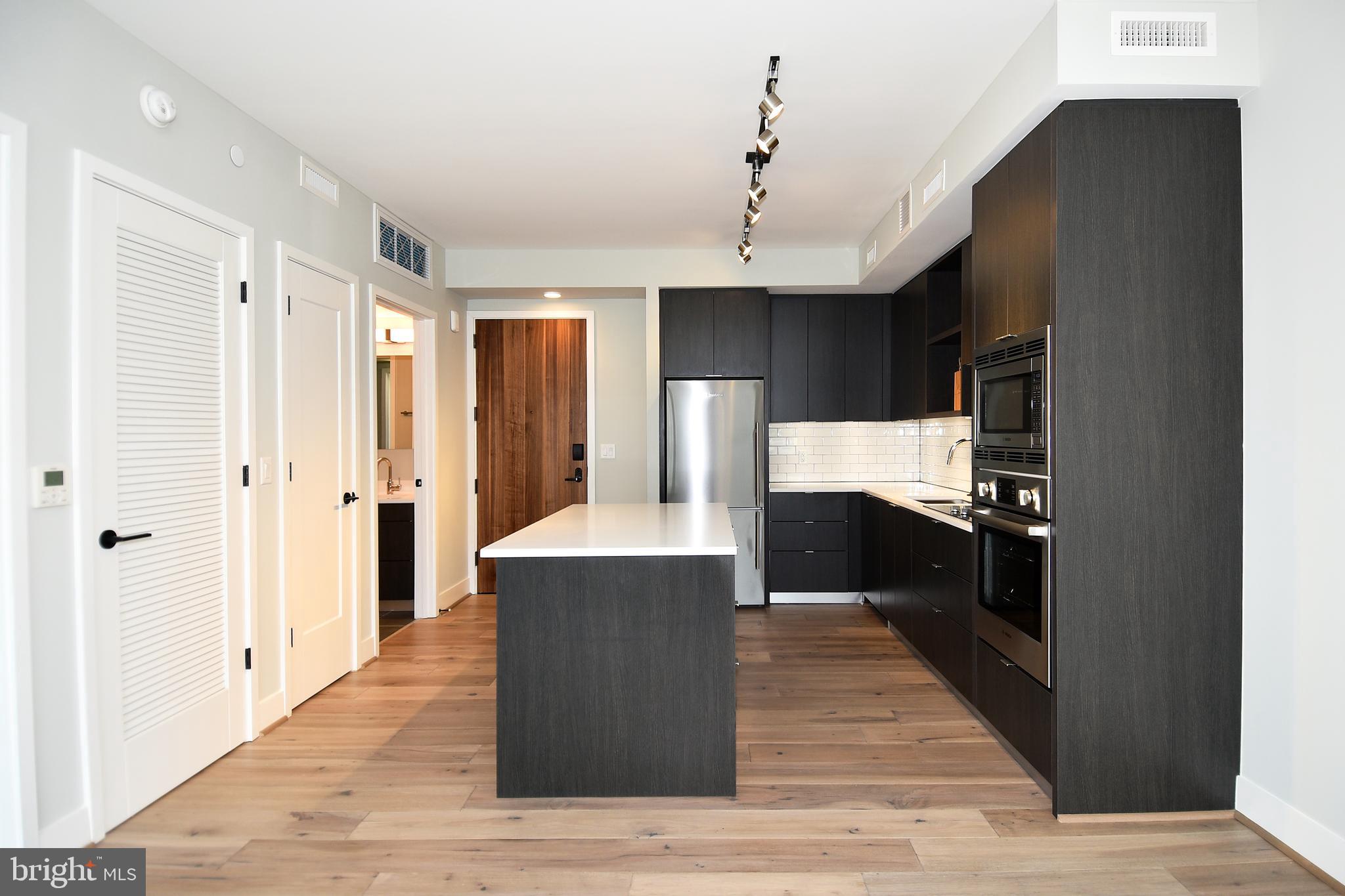 1300 4th Street Southeast, Unit 413 Washington, DC 20003 - Photo 5 of 47 a kitchen with stainless steel appliances granite countertop a refrigerator and a sink