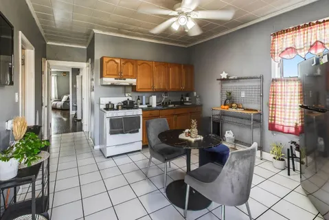 a dining room with furniture a chandelier and kitchen view