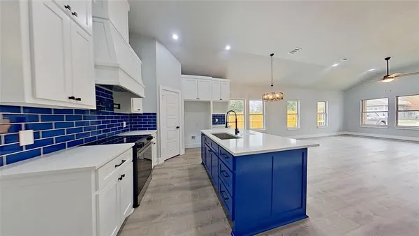 a kitchen with kitchen island granite countertop a sink appliances and cabinets