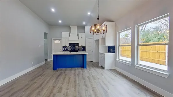 a open kitchen with stainless steel appliances granite countertop a stove a refrigerator and a wooden floors