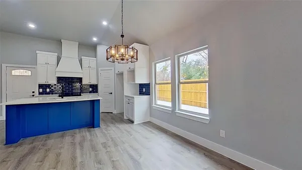 a large kitchen with stainless steel appliances kitchen island granite countertop a stove a sink dishwasher and a wooden cabinets