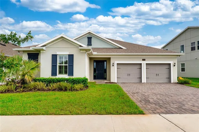 a front view of a house with a garden and lake view
