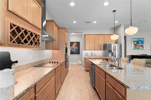 a living room with furniture kitchen view and a wooden floor