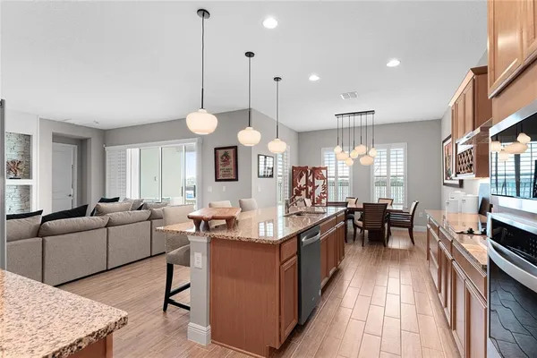 a dining room with wooden floor a chandelier a wooden table and chairs