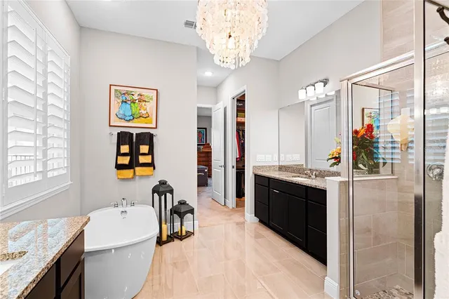 a bathroom with a granite countertop sink and a bathtub