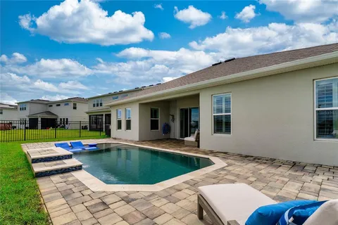 a view of swimming pool with outdoor seating and yard in back