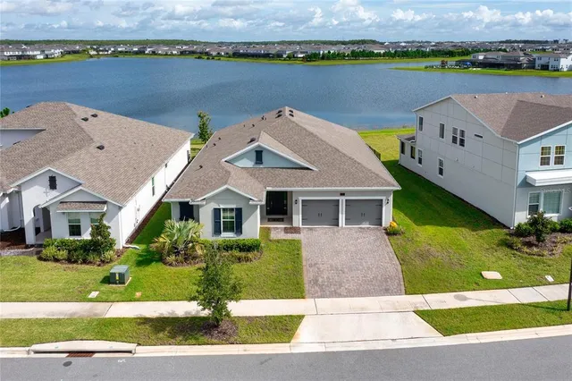 an aerial view of a house with garden space and lake view