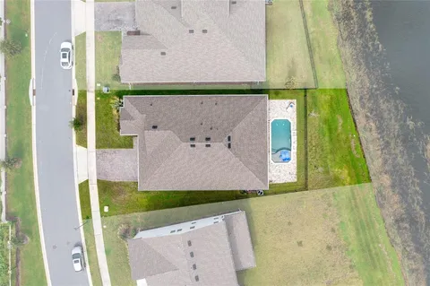 an aerial view of residential houses with outdoor space and ocean view