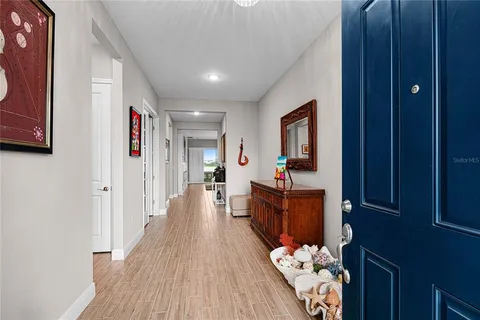 a view of a hallway with wooden floor and furniture