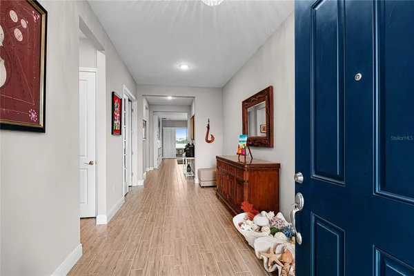 a view of a hallway with wooden floor and furniture