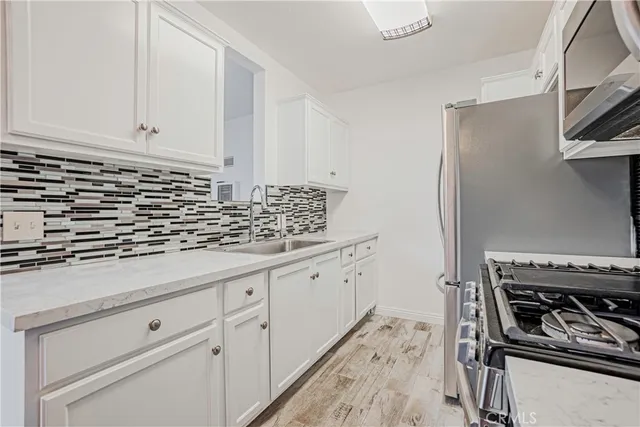 a kitchen with stainless steel appliances granite countertop a stove and a refrigerator