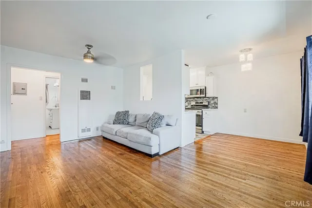 a living room with kitchen island furniture and wooden floor