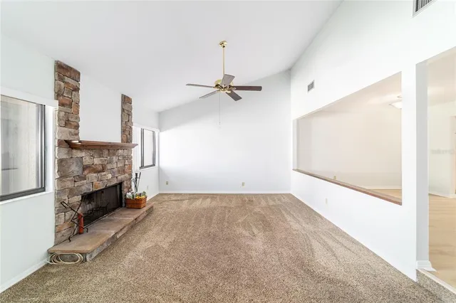 a view of empty room with fireplace and fan