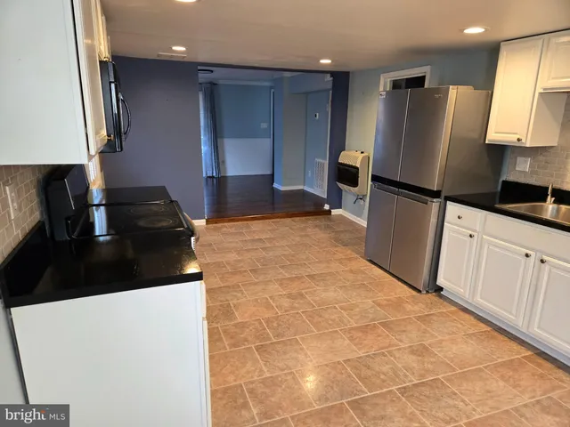 a kitchen with granite countertop a refrigerator and a sink