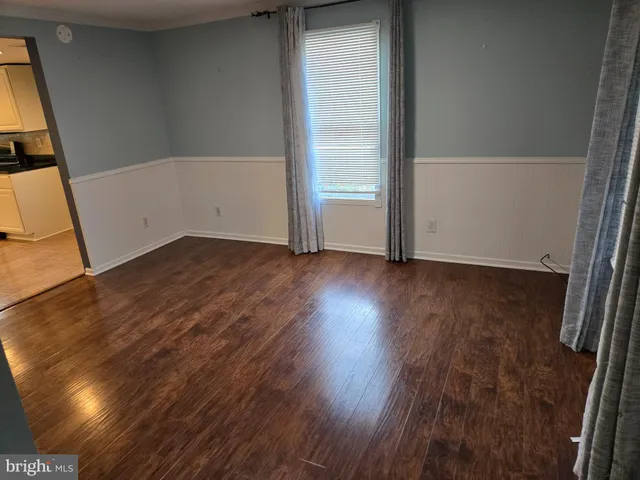 an empty room with wooden floor and mirror