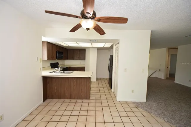 a view of kitchen with granite countertop cabinets and window