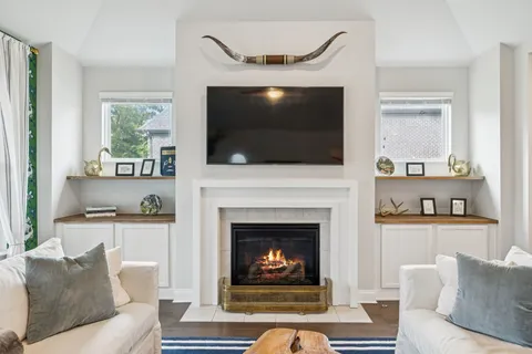 a living room with furniture a flat screen tv and a fireplace