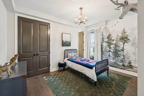 a spacious bedroom with a bed and a chandelier