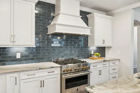 a kitchen with stainless steel appliances white cabinets and a stove
