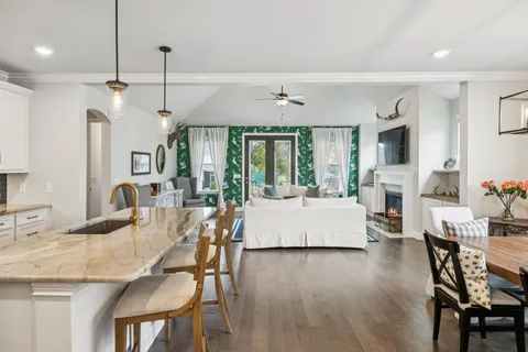 a dining room with furniture a chandelier and wooden floor