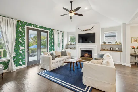 a living room with furniture fireplace and a large window