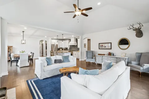 a living room with furniture and a view of kitchen