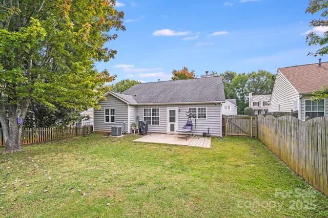 a view of a house with a big yard potted plants and large tree