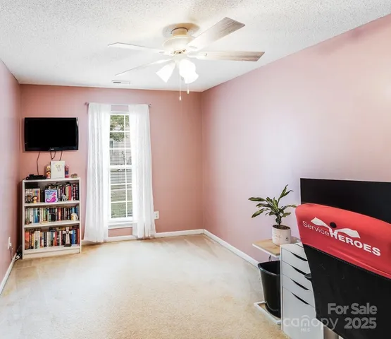 a view of an empty room with a window and a flat screen tv