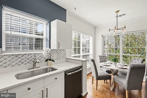 a kitchen with granite countertop a sink and white cabinets
