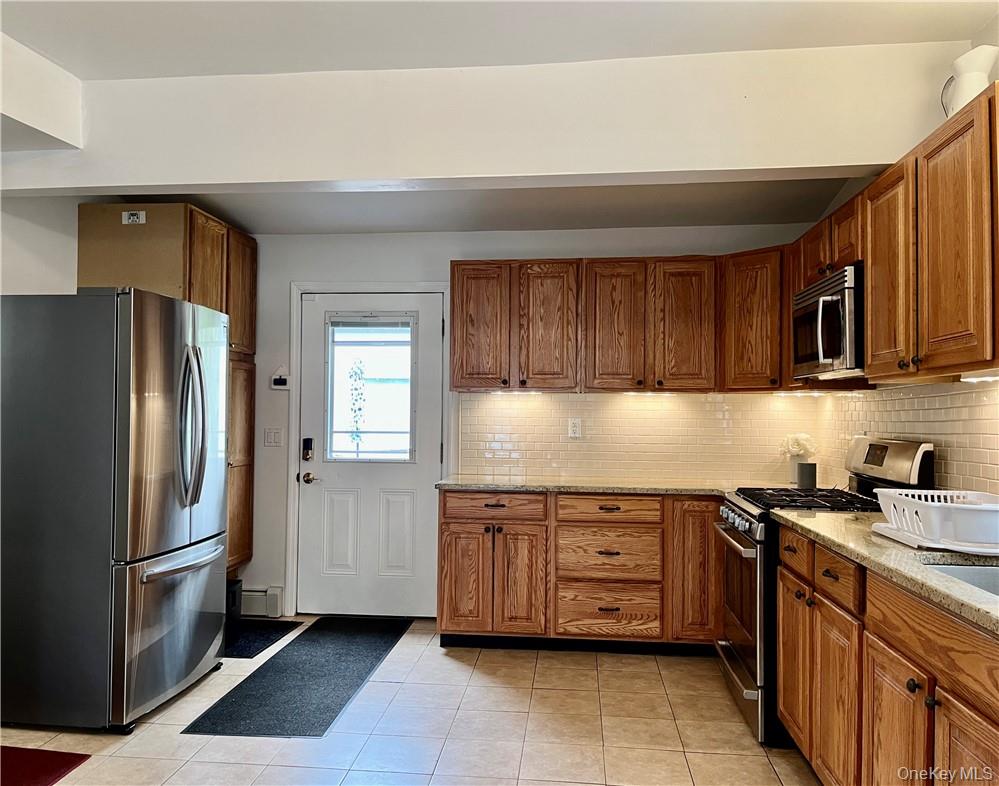 6 Cottage Street, Unit 2 Warwick, NY 10990 - Photo 7 of 12 a kitchen with stainless steel appliances granite countertop a refrigerator a sink a stove a microwave and island