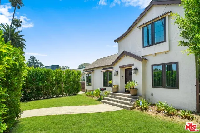a view of house and garden with large trees