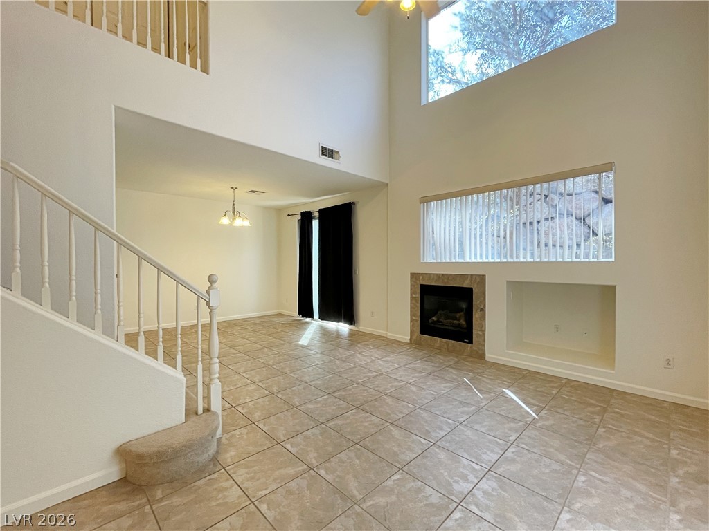 691 Principle Point Avenue Henderson, NV 89012 - Photo 3 of 30 A spacious living area features high ceilings and a cozy fireplace, perfect for gatherings.