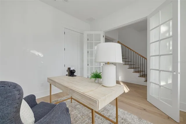 a view of a bedroom with wooden floor and windows