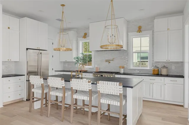 a kitchen with granite countertop a table and chairs in it