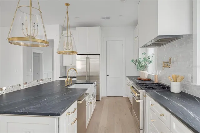 a kitchen with a stove a refrigerator and a table