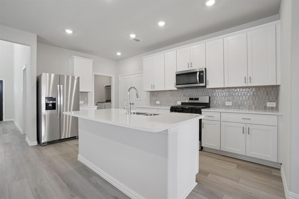 809 River Lane Lavon, TX 75166 - Photo 14 of 39 a kitchen with white cabinets and stainless steel appliances
