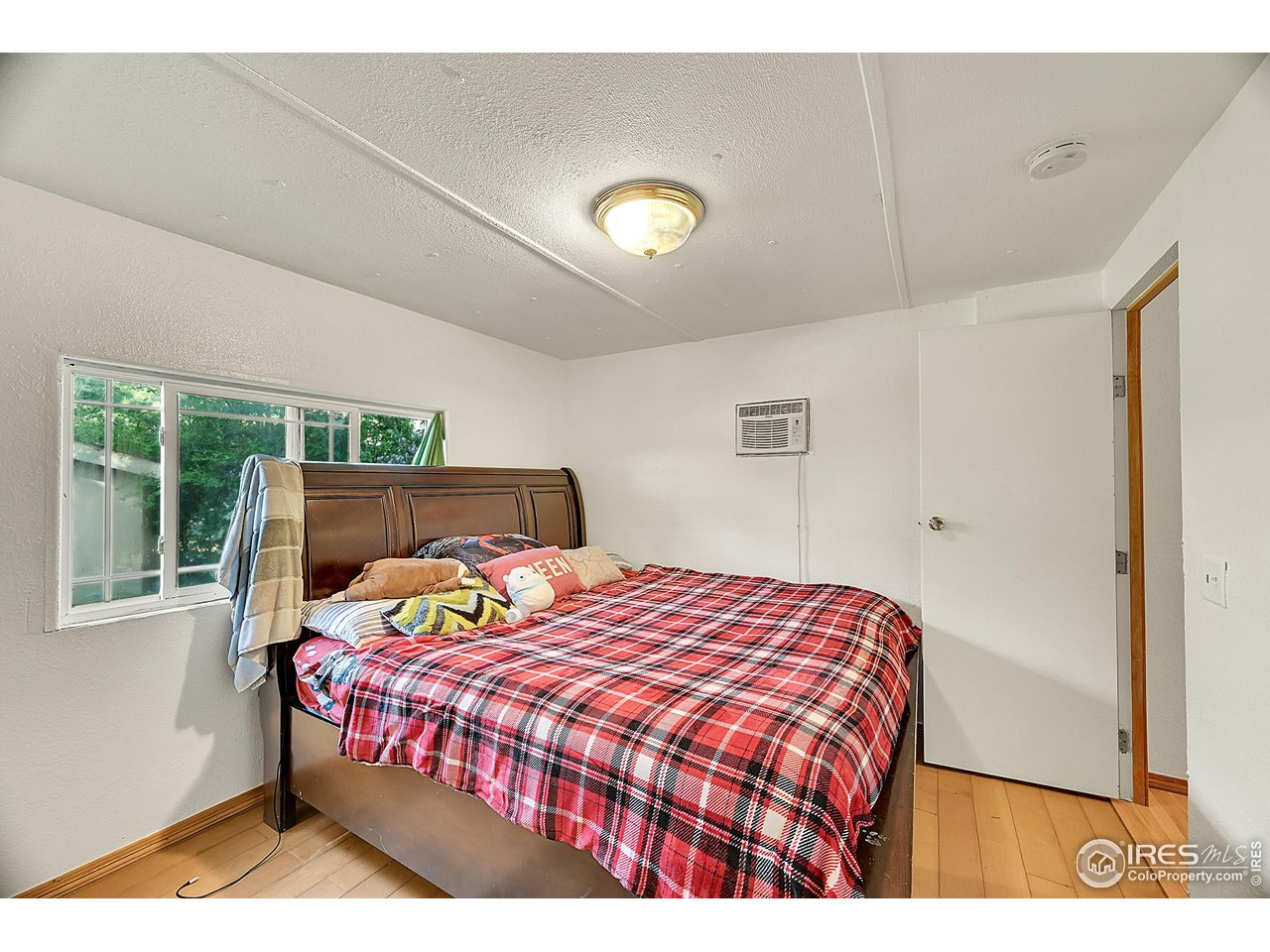 2500 East Harmony Road, Unit 178 Fort Collins, CO 80528 - Photo 10 of 22 a bedroom with a bed and wooden floor