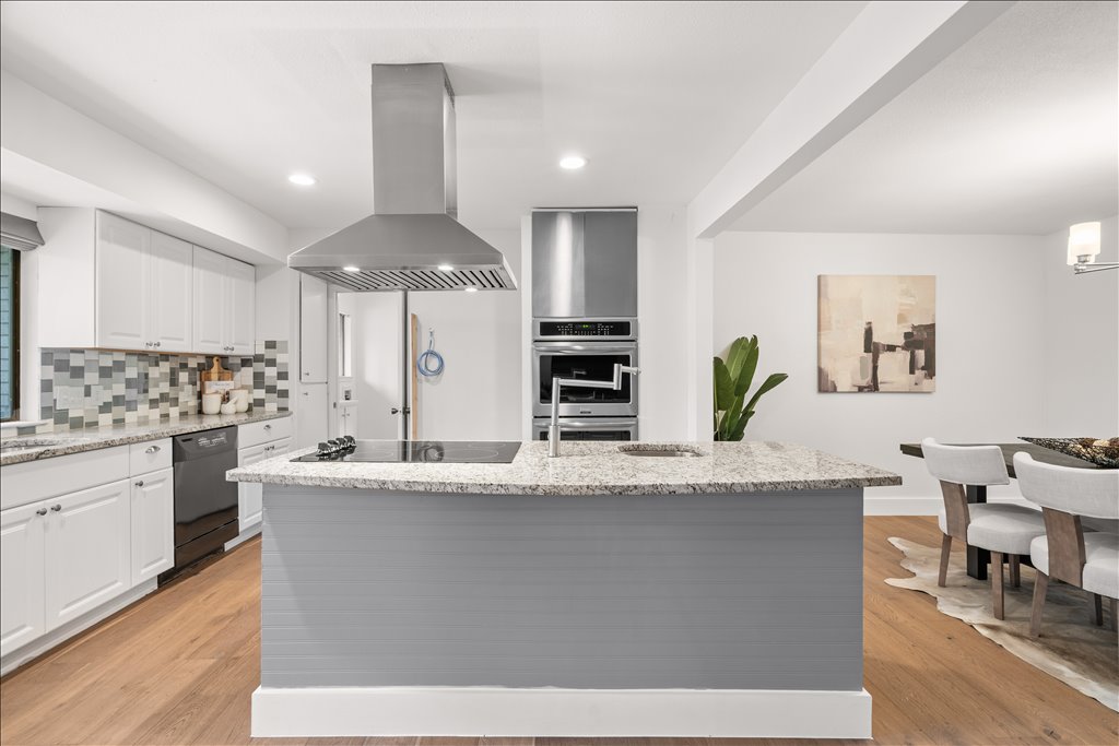 3402 Saddlestring Trail Austin, TX 78739 - Photo 16 of 33 Kitchen with island exhaust hood, light wood-style flooring, a kitchen island with sink, light stone countertops, and recessed lighting