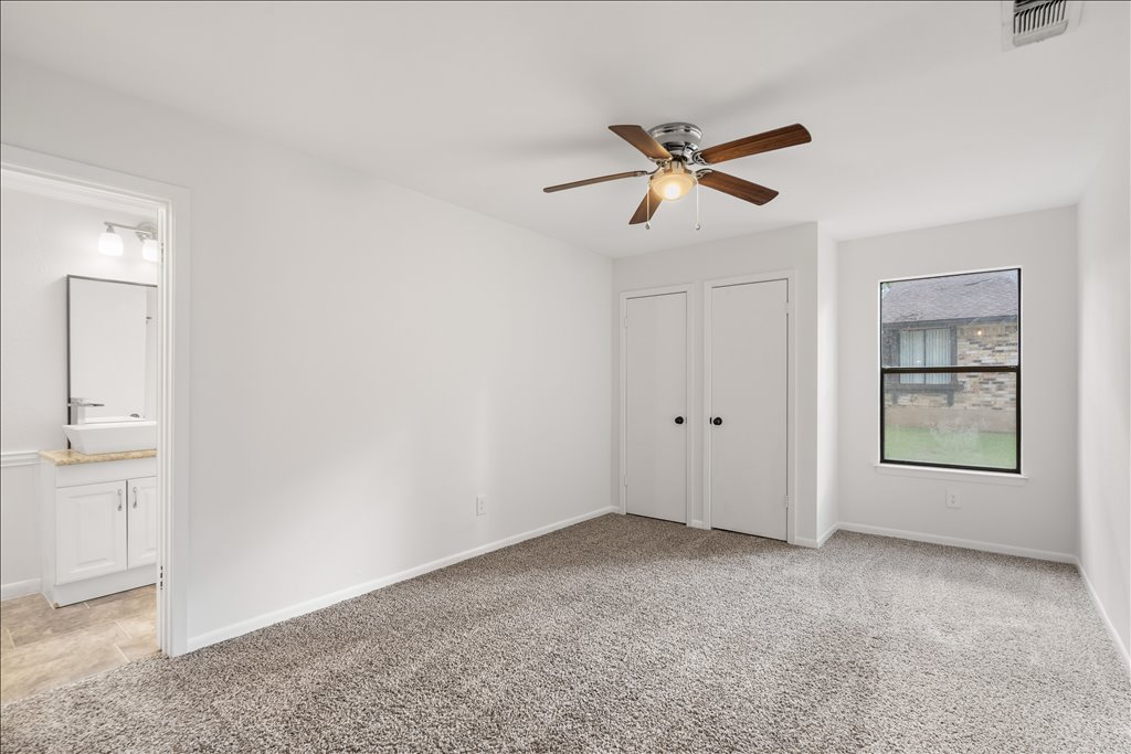 3402 Saddlestring Trail Austin, TX 78739 - Photo 29 of 33 Unfurnished bedroom with light carpet, multiple closets, and ceiling fan