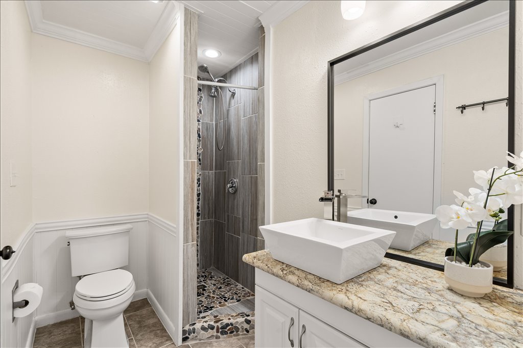 3402 Saddlestring Trail Austin, TX 78739 - Photo 30 of 33 Full bathroom featuring crown molding, a stall shower, vanity, a wainscoted wall, and light tile patterned floors