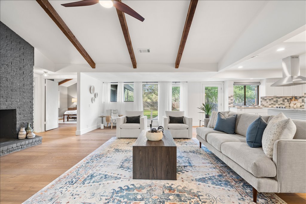 3402 Saddlestring Trail Austin, TX 78739 - Photo 10 of 33 Living area with light wood-type flooring, a large fireplace, lofted ceiling with beams, ceiling fan, and recessed lighting