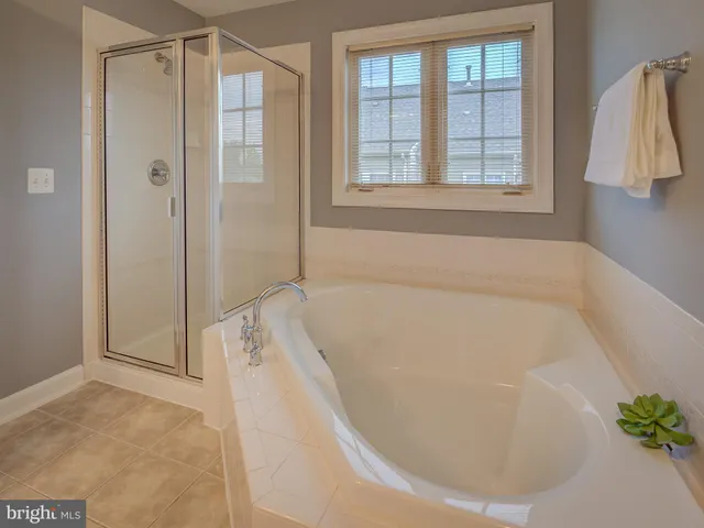 a kitchen with stainless steel appliances granite countertop a refrigerator a sink dishwasher a stove and white countertops with wooden floor