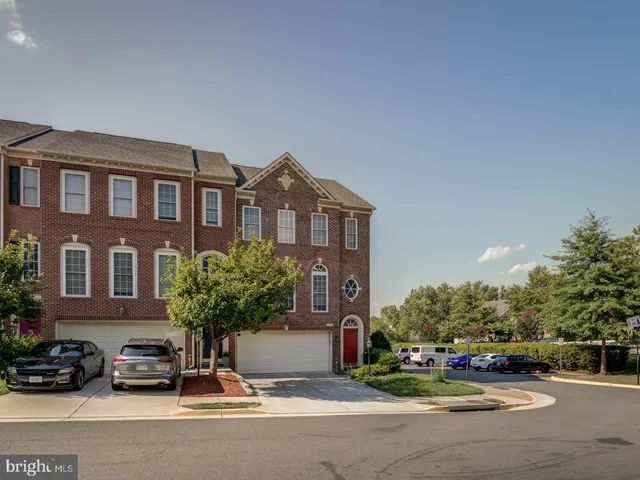 a car parked in front of a brick house with a yard
