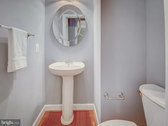 a bedroom with a large bed a couch and wooden floor