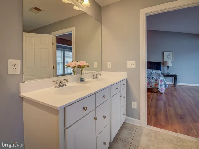 a spacious bathroom with a double vanity sink and a mirror