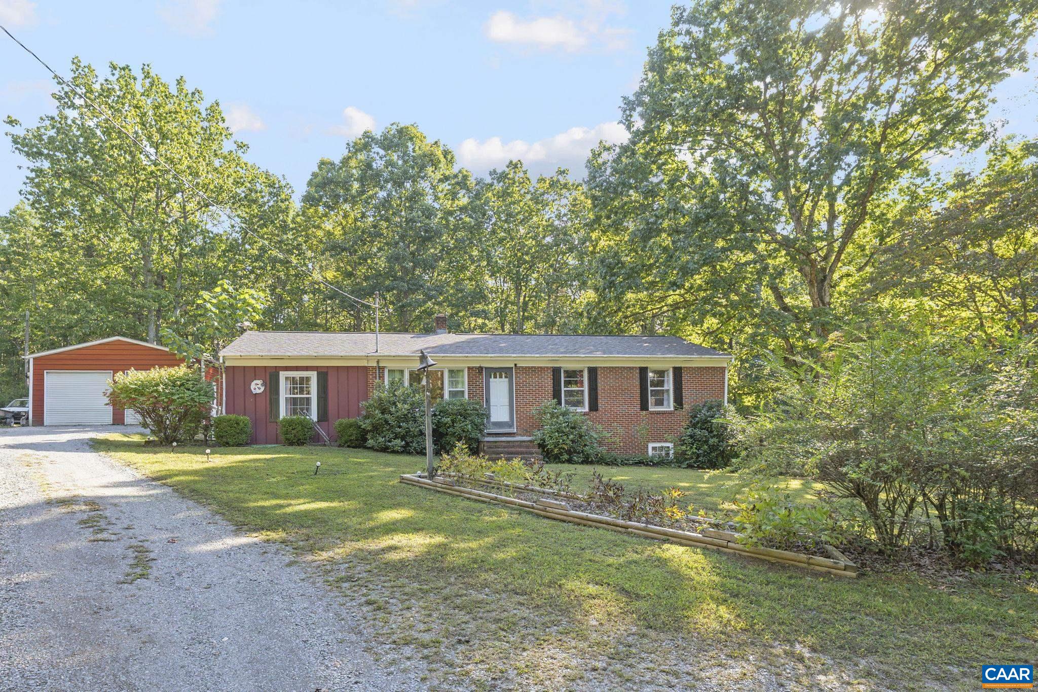 9020 West River Road Palmyra, VA 22963 - Photo 1 of 41 a front view of a house with a garden and trees